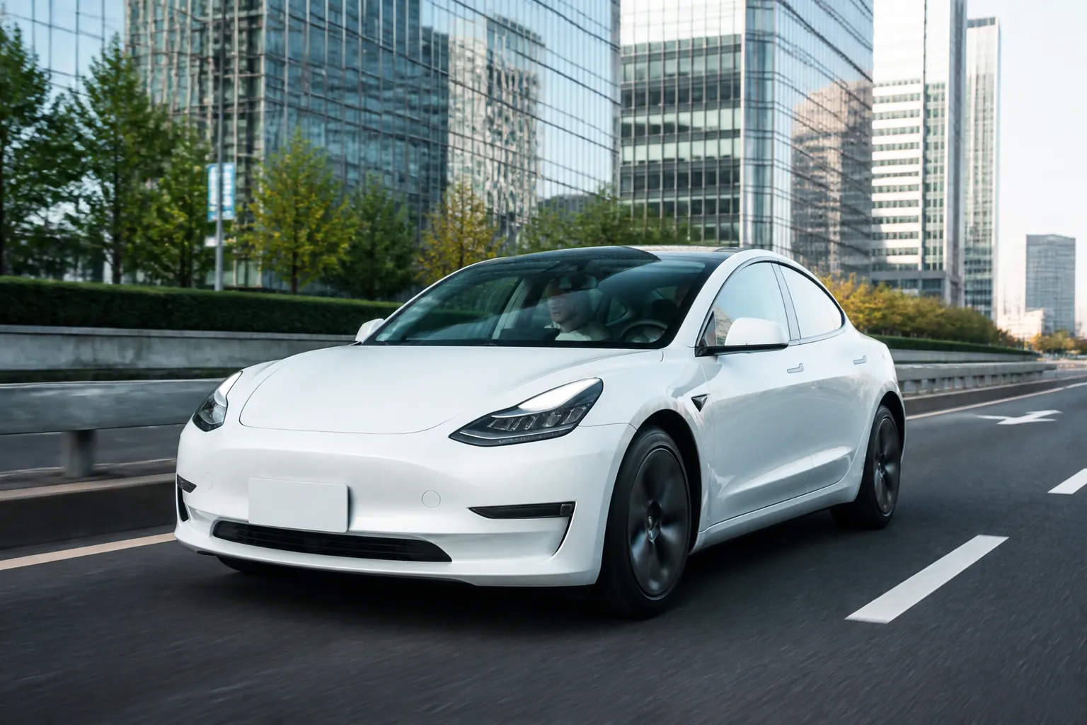 Tesla Model 3 на городской дороге у современного делового квартала. Автомобиль показан в реалистичной сцене без акцента на логотипы.