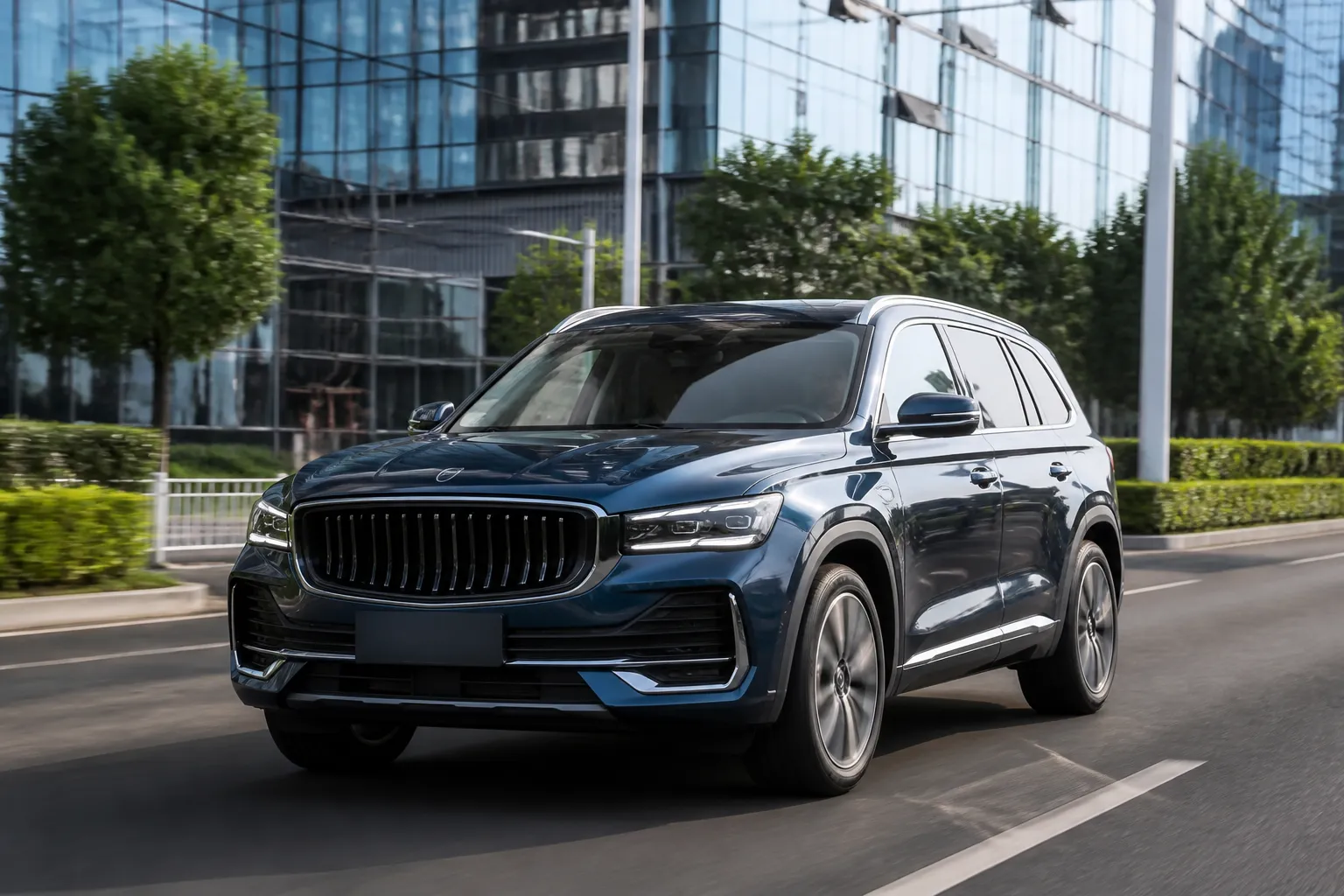 Geely Xingyue L на городской дороге в ясный день. Кроссовер снят спереди под углом на фоне современной городской застройки.