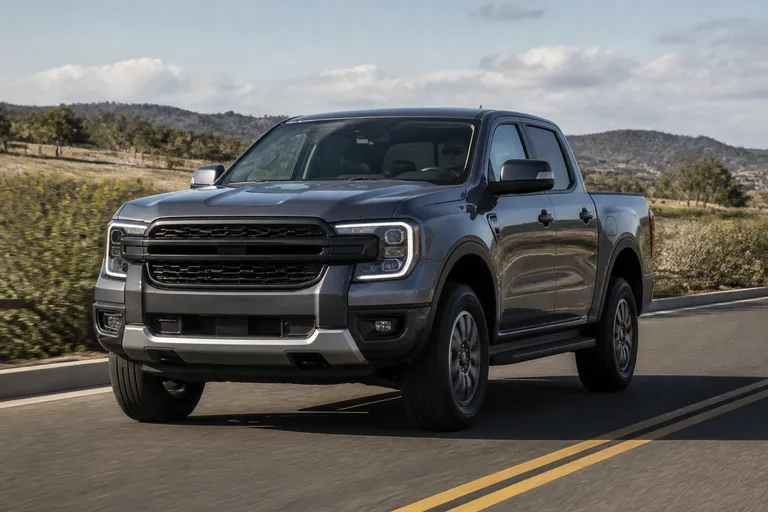 Новый Ford Ranger на дороге за городом, рядом видна открытая местность и легкий внедорожный рельеф. Сцена показывает пикап как автомобиль для работы, путешествий и загородных маршрутов.