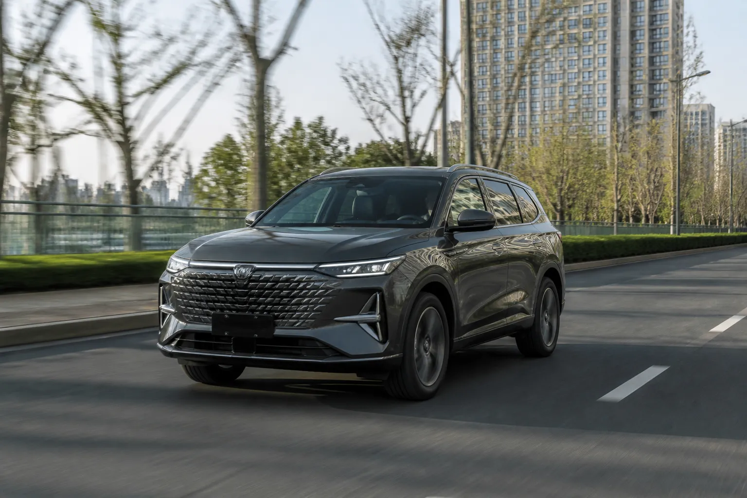 Новый кроссовер Changan CS75PLUS на городской дороге перед выездом на трассу. Машина снята в реалистичной дорожной обстановке без рекламных надписей.