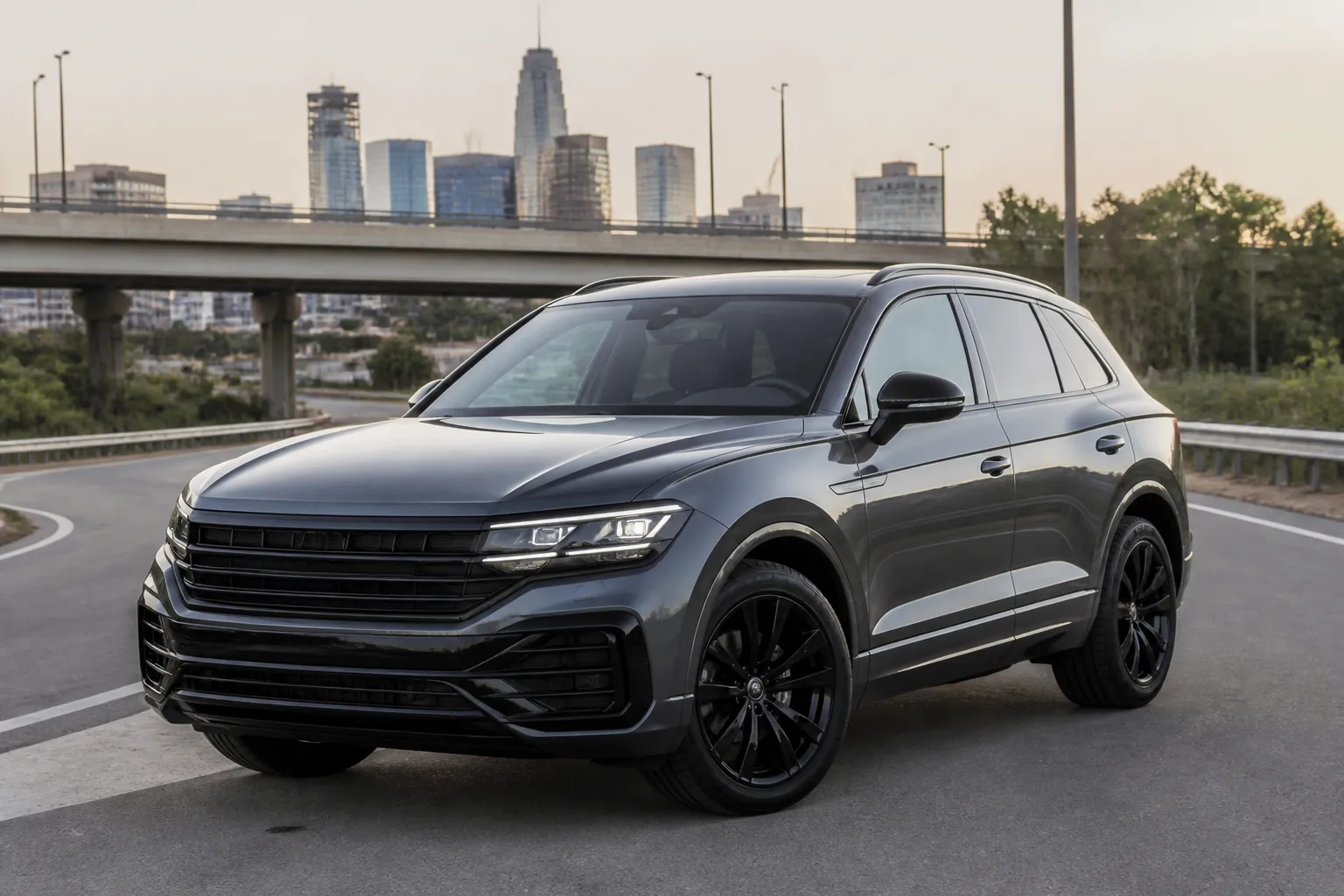 Volkswagen Touareg стоит на городской дороге перед выездом на трассу. Крупный кроссовер показан в реалистичной обстановке, акцент на кузове и уверенной посадке автомобиля.