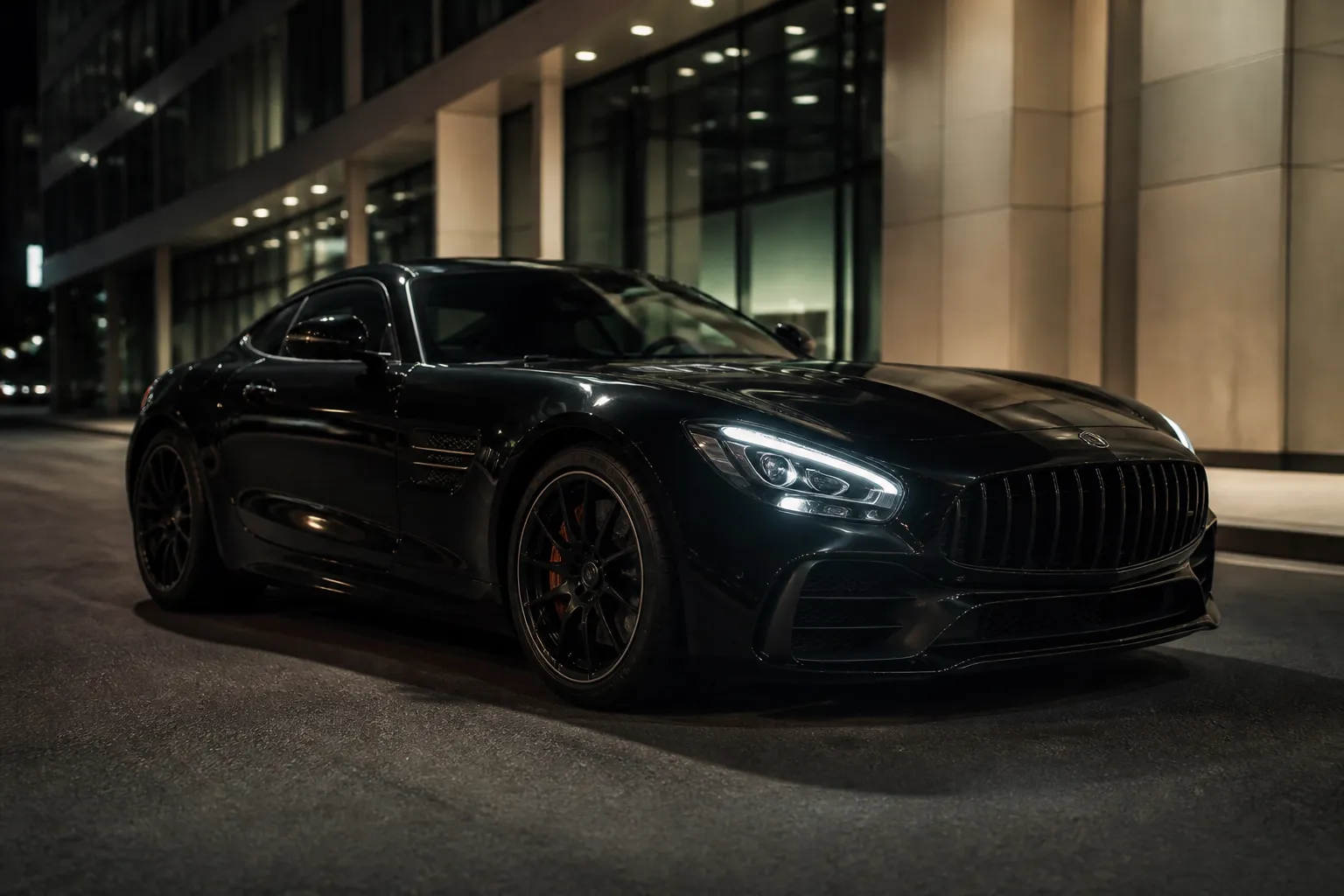 Mercedes-Benz AMG GT на вечерней городской дороге, снятый спереди в три четверти. Автомобиль стоит у обочины на фоне современной архитектуры.