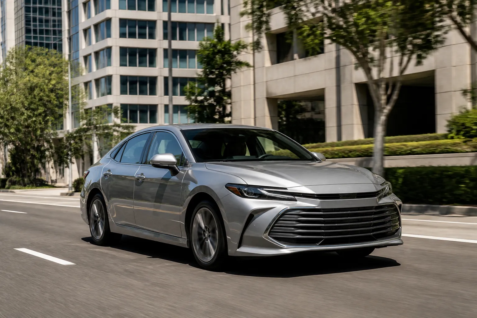 Toyota Avalon на городской дороге, крупный седан показан спереди под углом в естественном дневном свете.