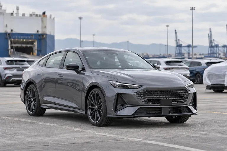 Changan UNI-V стоит на площадке перед осмотром перед покупкой. Кадр подчёркивает выбор версии и проверку автомобиля перед ввозом.